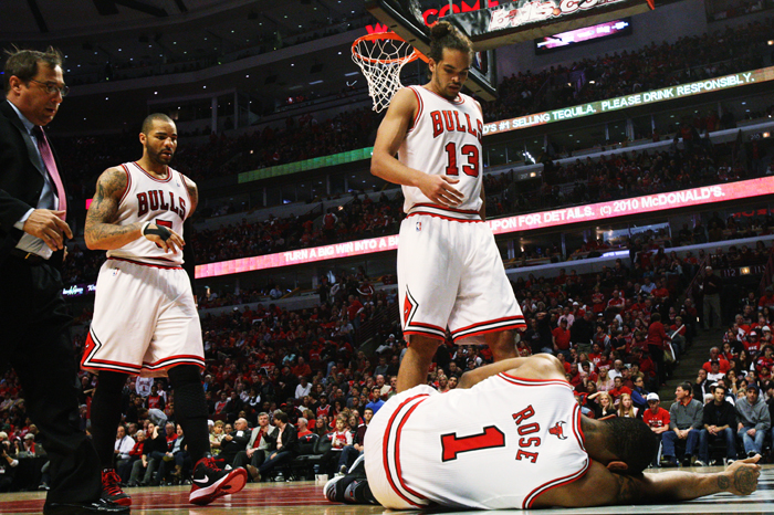 Players and trainers rush to the aid of Chicago Bulls’ Derrick Rose  after he injured his knee  against the Philadelphia 76ers in Game 1 of the Eastern Conference first-round series at the United Center in Chicago, Ill., Saturday, April 28, 2012.
