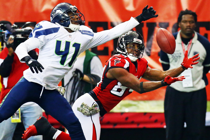 Atlanta Falcons wide receiver Roddy White attempts to catch a pass against a Seattle Seahawks defender during a home game against Seattle, Nov. 10, 2013.