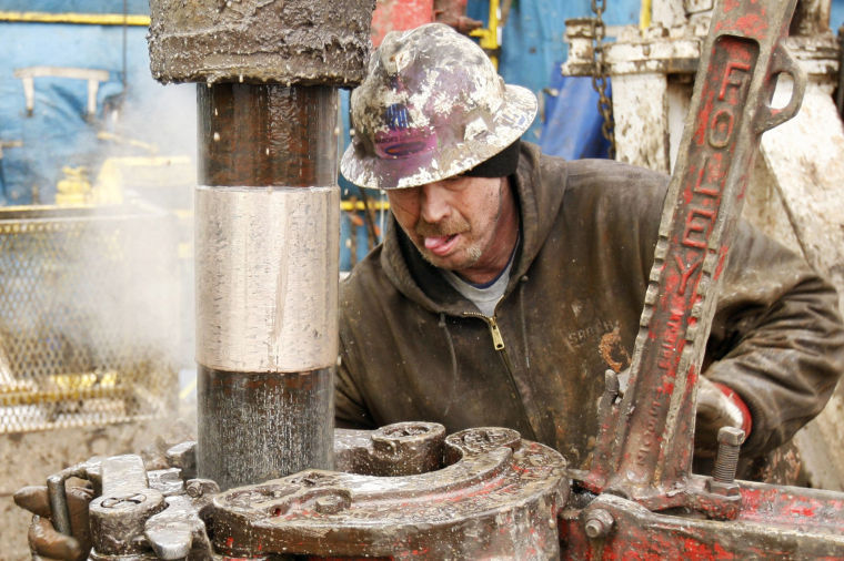 Deckhands on a Sandridge Energy oil rig change out a drill pipe during a fracking operation on the Oklahoma border in Harper County, Kan., Feb. 5, 2012.