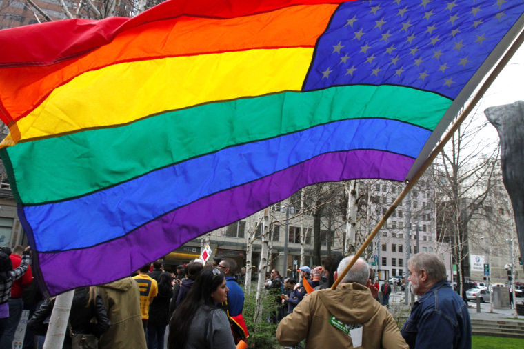 A gay marriage supporter flies a rainbow flag during a rally in Seattle, March 2013.