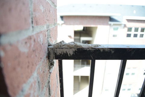 Excess mortar from recent construction at The Grove apartments has dried onto railing, Sunday, Aug. 24, 2014.