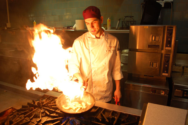 Executive Chef at Hillside Cafe Jake Cho prepares a flaming dish in Northside Cafe, Oct. 11, 2014.