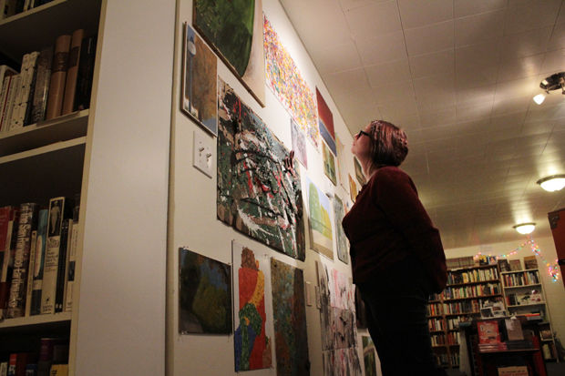 The owner of Palouse Books, Viva Stowell, observes the WSU student paintings on Thursday, November 13, 2014.