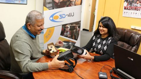 Uma and S. Jay Jayaram hold two virtual reality headsets used to view events in real-time.