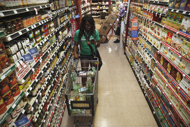 Instacart shopper Kara Pete looks over a list of groceries as she walks the aisles of Whole Foods for customer Tricia Carr on Sept. 12, 2014 in Sherman Oaks, Calif.