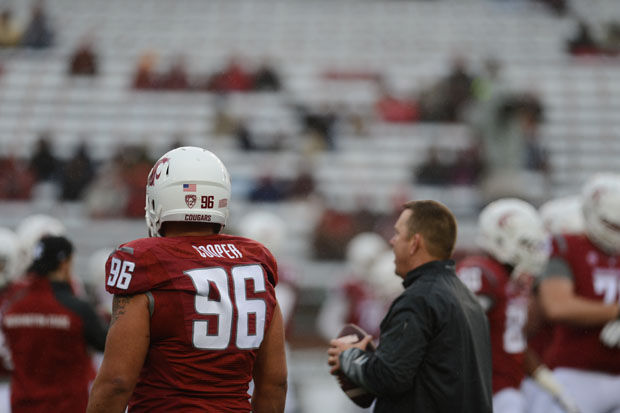 Former defensive end Xavier Cooper watches the offense from the sidelines as the Cougars play USC in Martin Stadium, November 1, 2014.