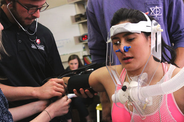 Going through the VO2 test in the Exercise Physiology and Performance Laboratory, a woman is tested on her performance through the monitoring of her oxygen intake.