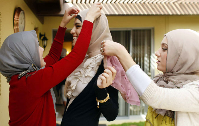 The hijab is a symbol of cultural identity, the understanding of which starts at the individual level. Friends Nora Diab, left, and Marwa Atik, right, adjust a new hijab on friend Marwa Biltagi in the backyard of Atiks home in Fountain Valley, California. 