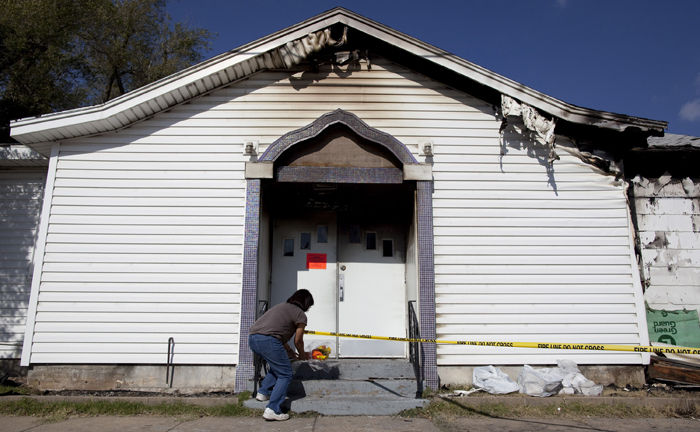A woman places flowers on Nov. 1, 2011, at the entryway of a mosque in west Wichita, Kansas, that was damaged by fire the day prior.