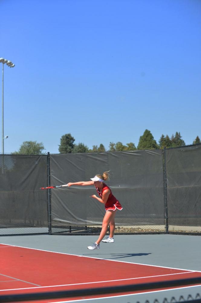 A WSU tennis player serves the ball over the net during the Cougar Classic at the Outdoor Tennis Courts, Sept. 12.