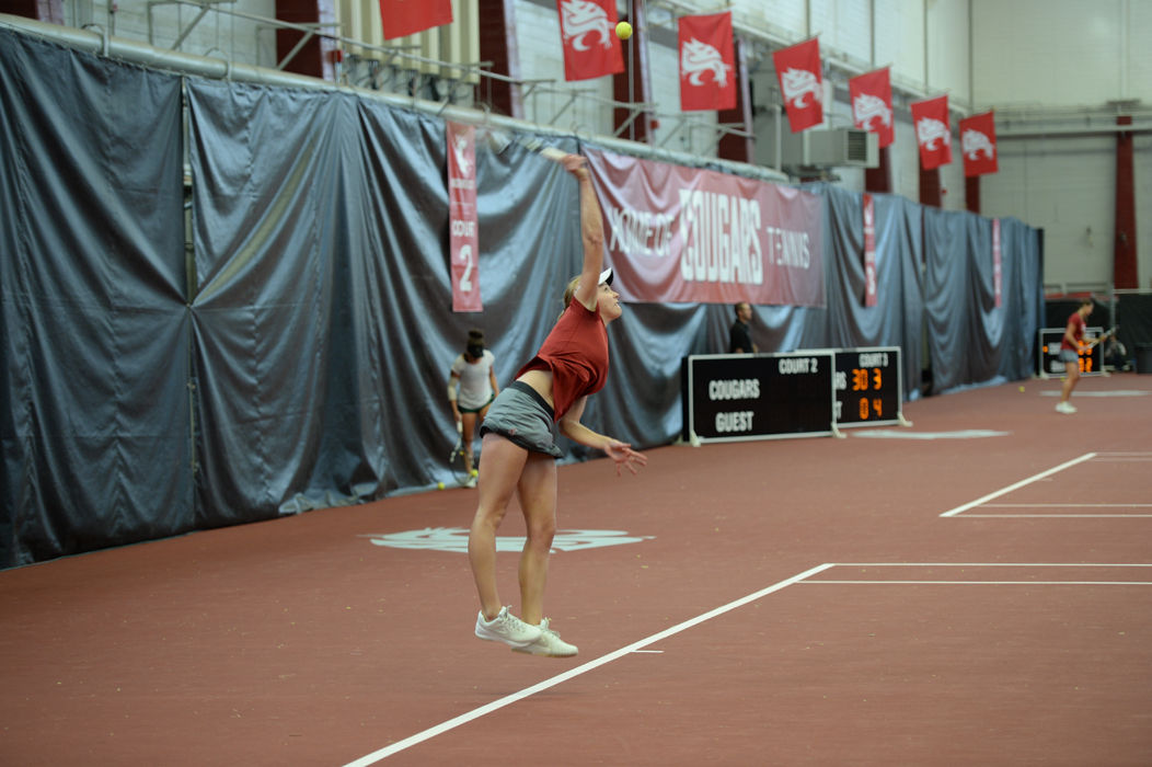 A WSU tennis player looks up towards the ball during a match against  North Texas in Hollingbery Fieldhouse on Jan. 31.