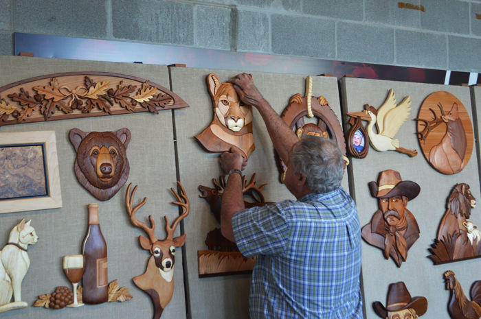 Don Bunch hangs wood carvings from his company Wooden Wonders.