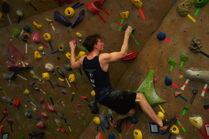 A student competes in a bouldering competition on Feb. 2 at the Student Recreation Center.