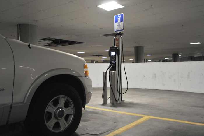 A car parked in front of the electric vehicle charging station in the parking garage beneath the Terrell Library.