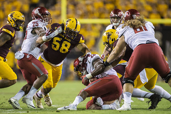 WSU redshirt junior running back Gerard Wicks, 23, is tackled by a Sun Devils defender during a game in Tempe, Arizona on Saturday. The Cougars won the game 37-32 and the win marked the program’s first in Sun Devil Stadium since 2001.