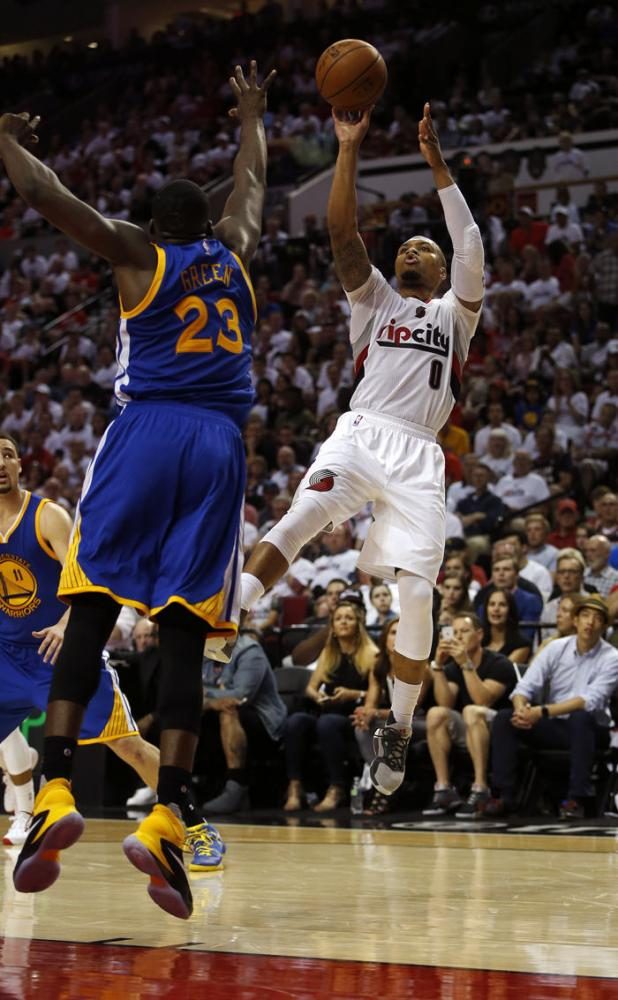 Trail Blazers’ Damian Lillard takes a contested shot against the Golden State Warriors.