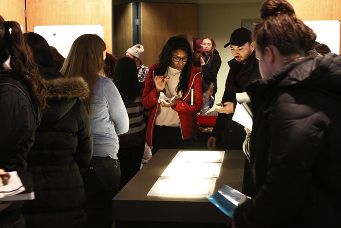 Onlookers gather to explore the Solar Decathlon exhibit on Monday evening in Carpenter Hall.