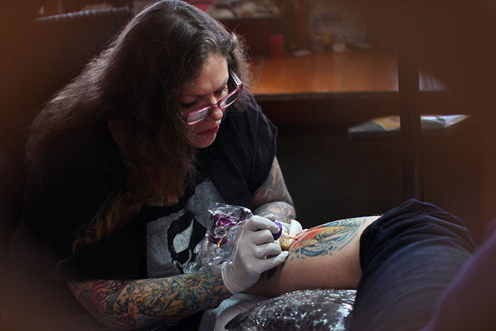 Telisa Swan does touch-up work on Brian Keeny’s tattoo on Tuesday at Swan Family Ink.