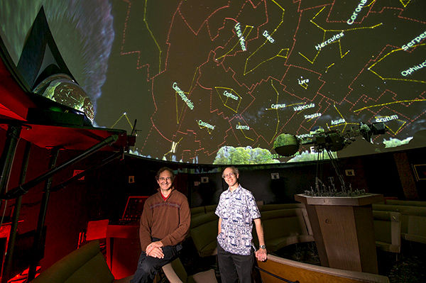 Guy Worthey and Michael Allen, WSU Planetarium co-directors, stand below the planetarium projector.