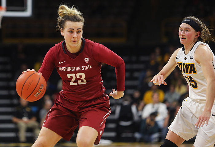 WSU sophomore guard Alexys Swedlund drives past Iowa defenders on her way to the basket on Sunday.