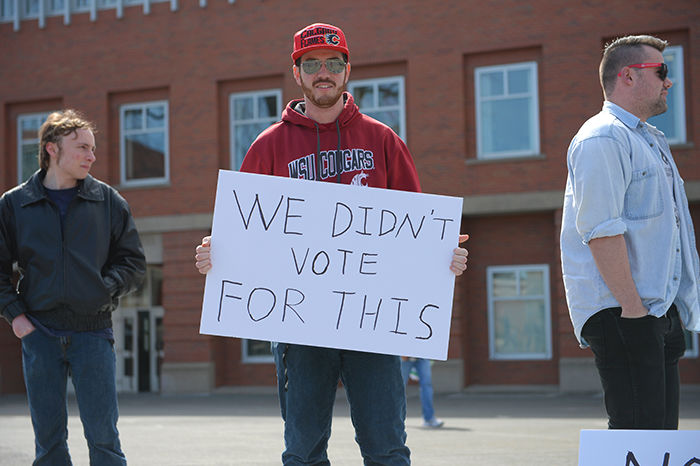 Max Schafer, center, brought his sign to protest the U.S. involvement in Syria.  The protest took place on the Todd Hall steps on Tuesday afternoon.
