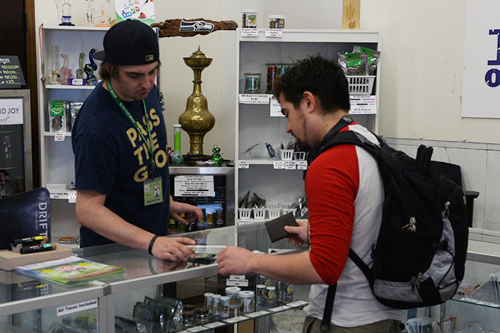 Aaron, an official bud tester at MJ’s, helps a customer inside of the shop.