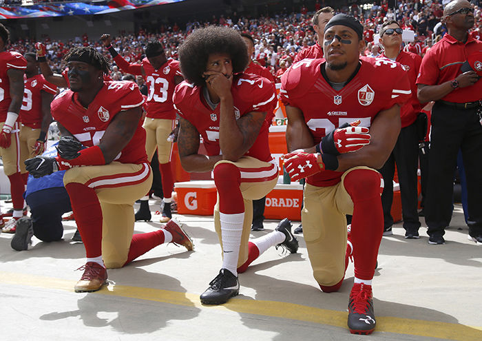 Former San Francisco quarterback Colin Kaepernick, center, and two teammates kneel during the national anthem in a game against the Dallas Cowboys on Oct. 2 at Levi’s Stadium.