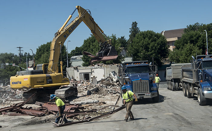Construction workers remove rubble from the site of the demolished Washington Federal Bank building Monday.
