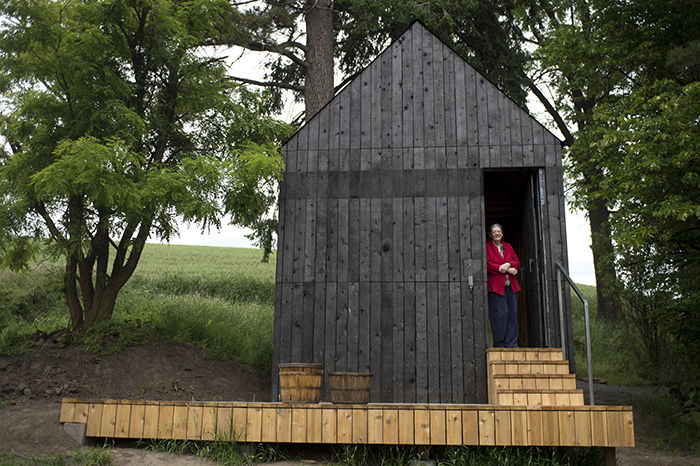 White Spring Ranch Curator Diane Conroy stands in the doorway of the Black Shed built by WSU students. They used a Japanese wood burning technique known as Shou Sugi Ban to achieve an aged look.