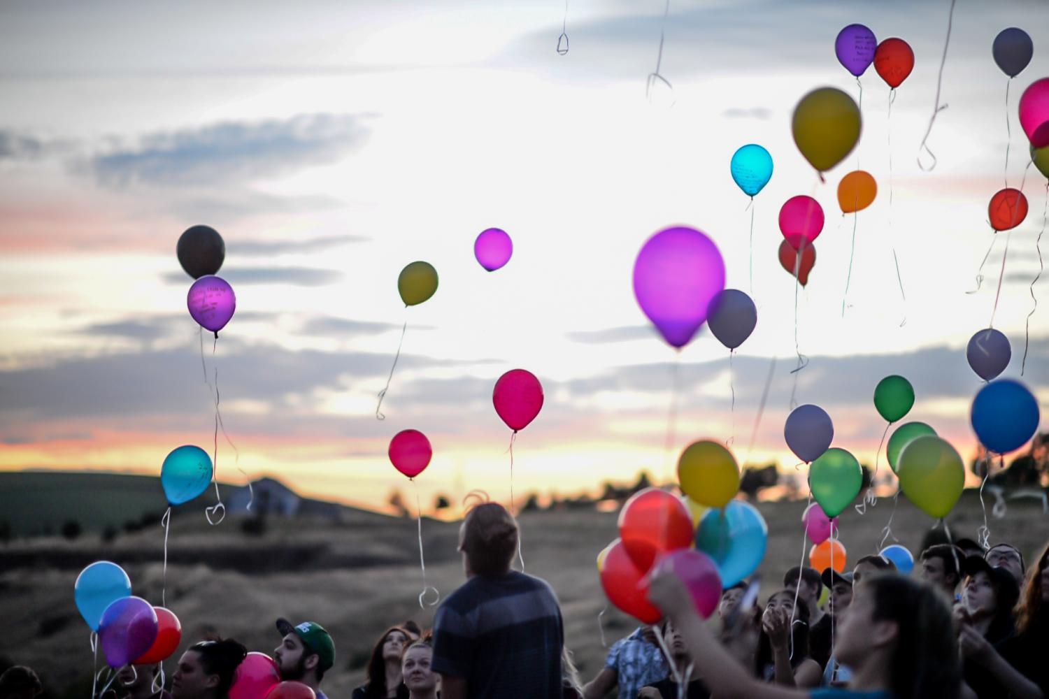 Friends and family members of Tim Reeves release balloons in remembrance Thursday night at Conservation Park in Pullman.