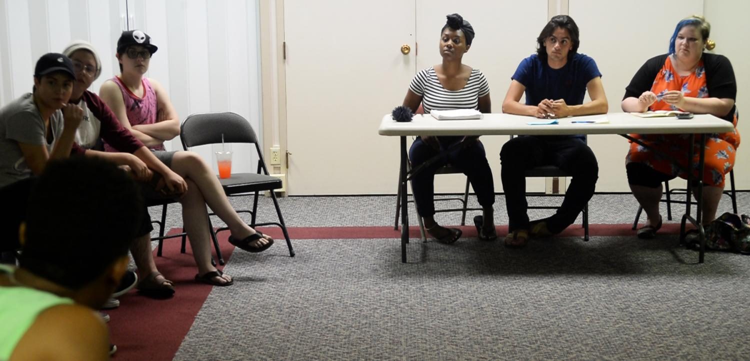 Lashae Daniels, left, Mohamed Salem, center, and Katherine Mary Meyer speak with volunteers at Tuesdays meeting for the march against white supremacy.