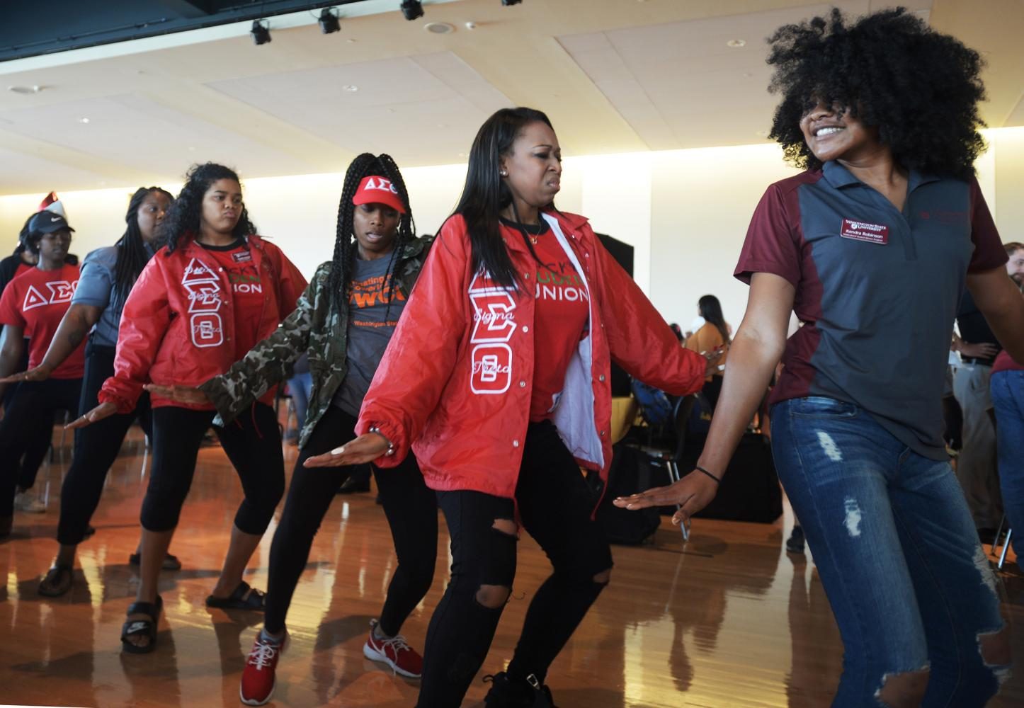 Delta Sigma Theta sorority members, fourth from the left, Renaye Tolbert, Alexis Jackson and Kendra Robinson dance 
at Conexion, hosted by Multicultural Student Services, on Sunday in the CUB Senior Ballroom.  