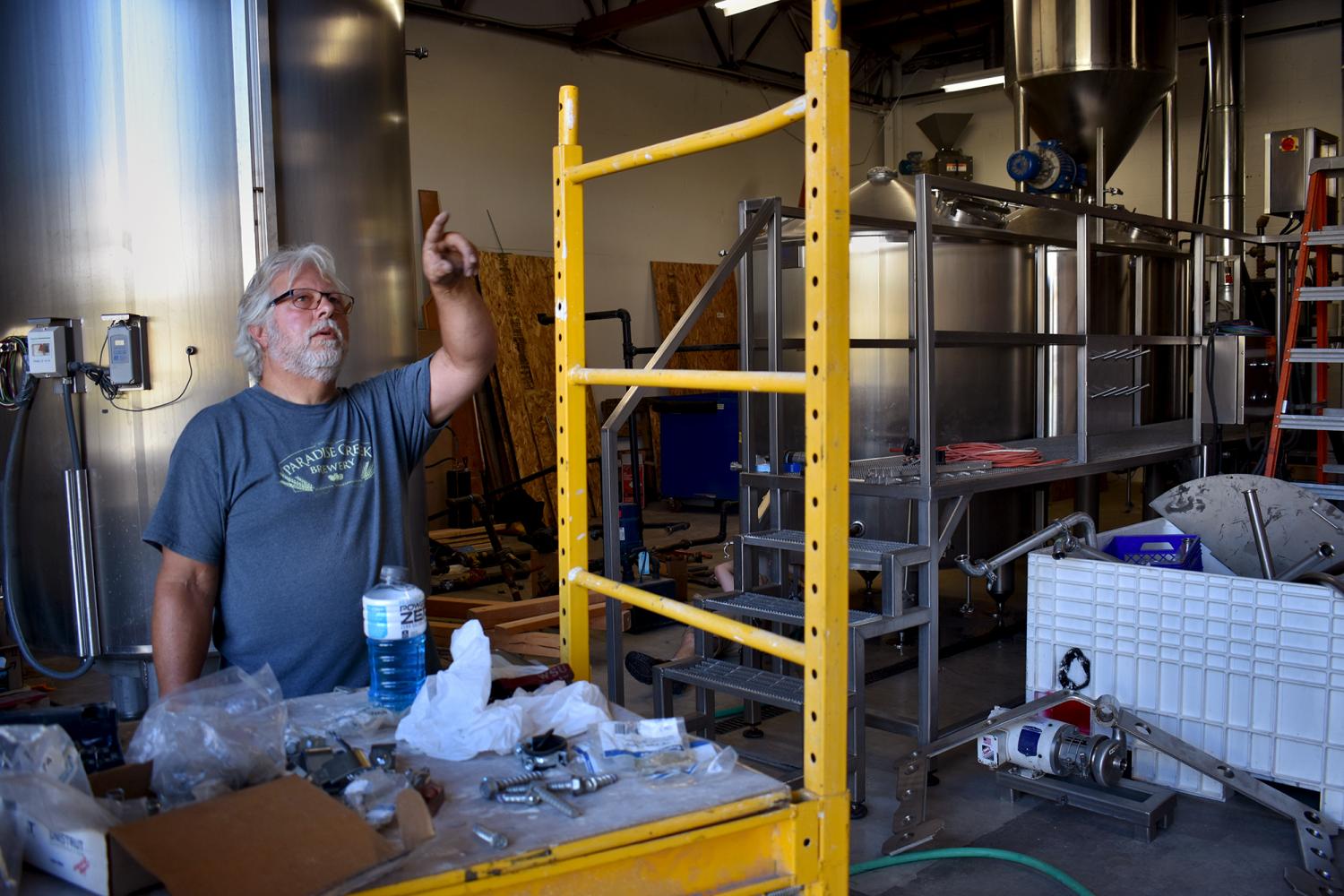 Tom Handy discusses the bare bones aesthetic and laid-back vibe of the new 
Paradise Creek Trailside bar; the brewerys grinder, boil kettle, and fermenter tanks will be visible to future patrons of the bar. 
