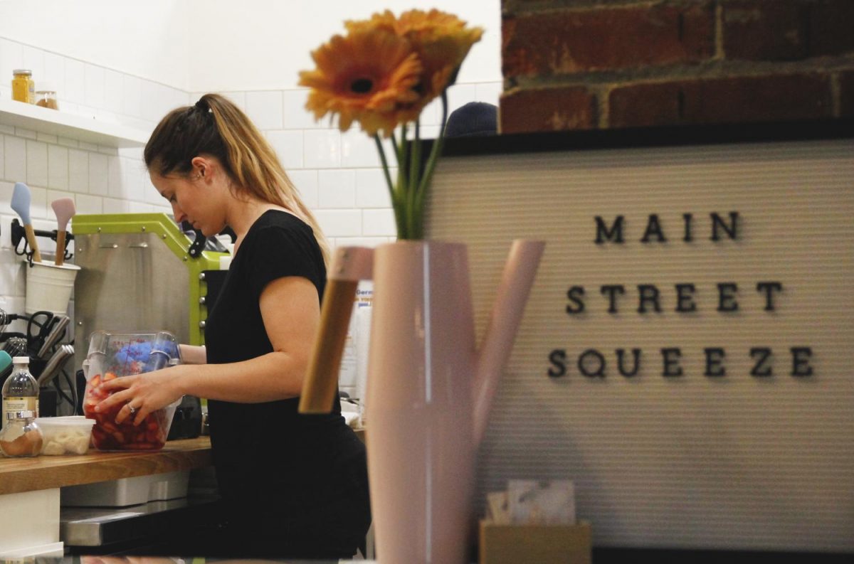 Owner of Main Street Squeeze and Sanctuary Yoga manager Destiny Sternod begins to make a smoothie
on her second day of business Tuesday. Sternod rented the space for the smoothie shop.