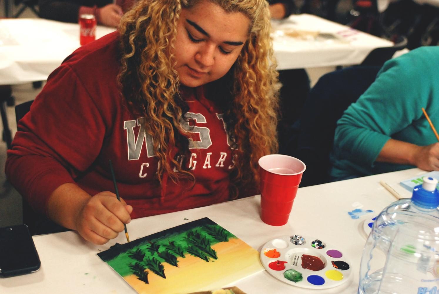 Student Gabby Oliva concentrates on painting a landscape at the WSU Student Entertainment Board Arts Hour event last night. SEB arranged two Arts Hours for students, with the goal of allowing them to express themselves creatively in a positive, encouraging environment.