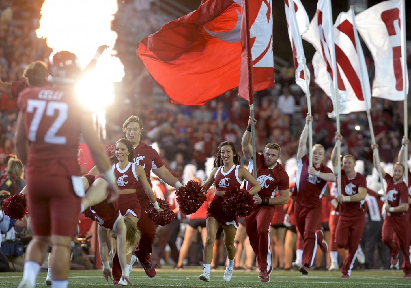 WSU Cougar football and cheerleading teams rush onto the field at the start of the game against Boise State University at Martin Stadium on Sept. 9.