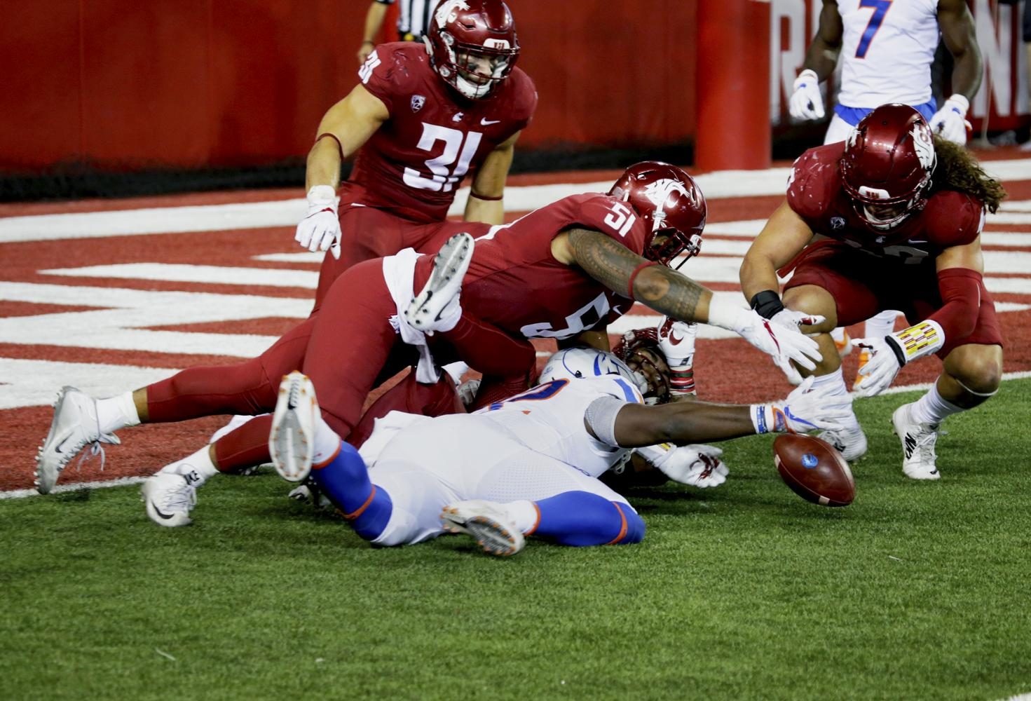 Senior linebacker Frankie Luvu recovers a fumble inside the Washington State Redzone against Boise State on Saturday. 