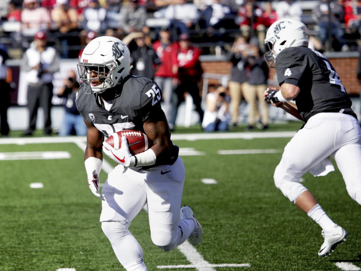 Redshirt senior running back Jamal Morrow runs with the ball following a handoff 
from Falk for a gain of yards against Nevada on Saturday.