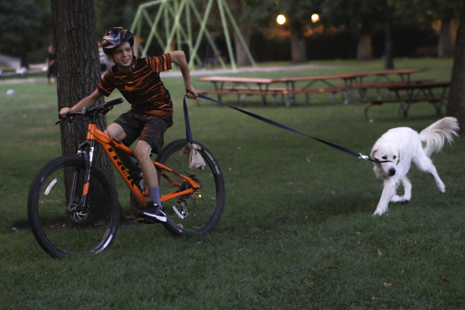 Petr Paulson training his dog Misha how to run alongside him on his bike Aug. 30.