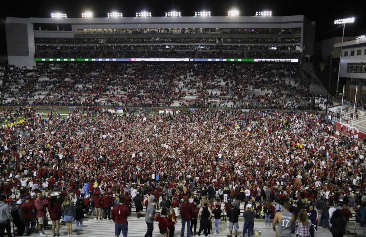 WSU fans storm the field after the teams 30-27 win over USC on Friday at Martin Stadium.
