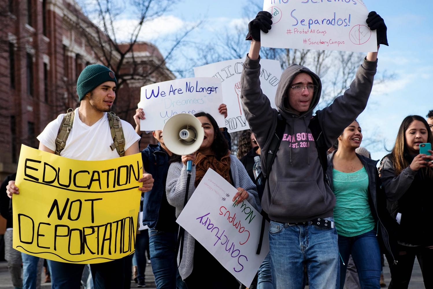 From left to right:  Eduardo Castañeda Díaz, Keyla Palominos and Michael Young-Bolton hold an education, not deportation sign at a protest December 1, 2016.