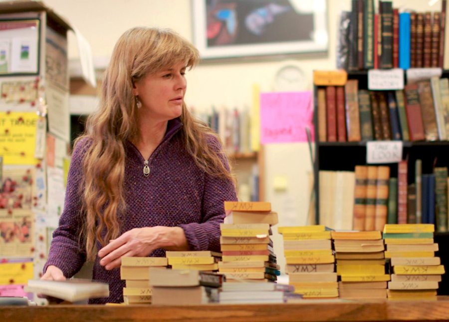 Monique Slipher helps customers at Bruised Books in downtown Pullman on Wednesday afternoon.