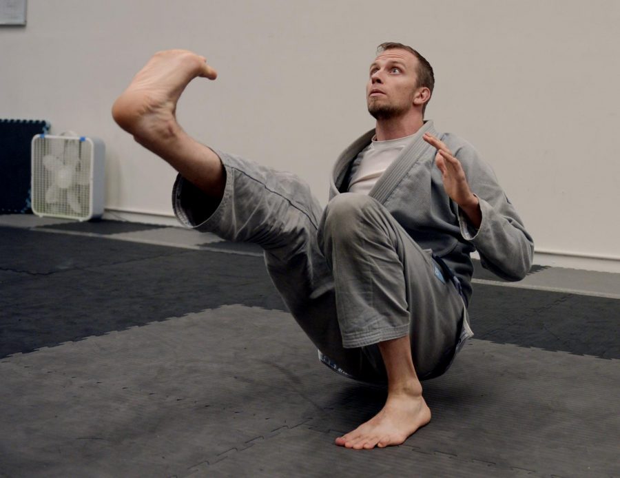 Shane McFarland, owner and jiu-jitsu teacher at Mantis Martial Arts, stretches before his class on Tuesday.