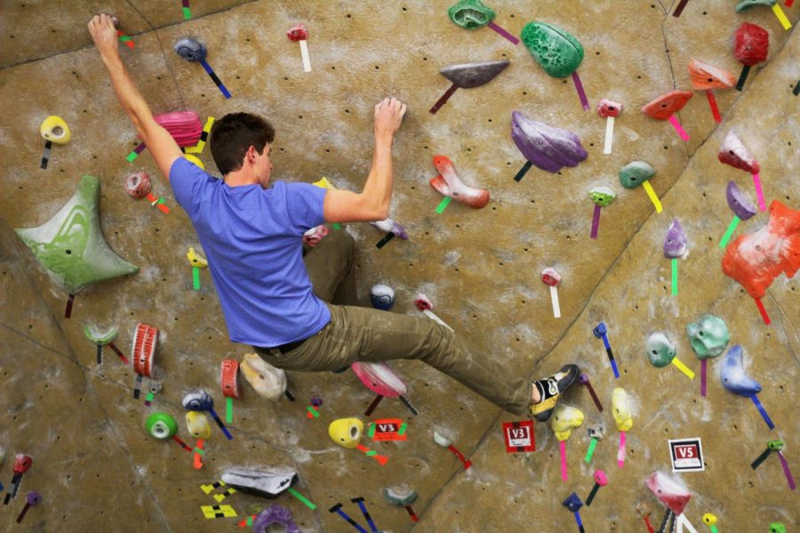 Senior and club President Connor Mullady climbs the Student Recreation Center rock wall after a club meeting Wednesday.