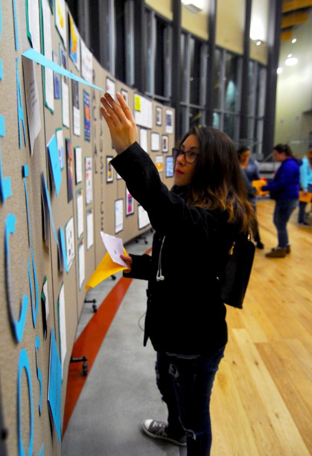 Freshman Julia Galindo reads information on socioeconomic status displayed for students waiting for their tour through the Room of Resistance. 