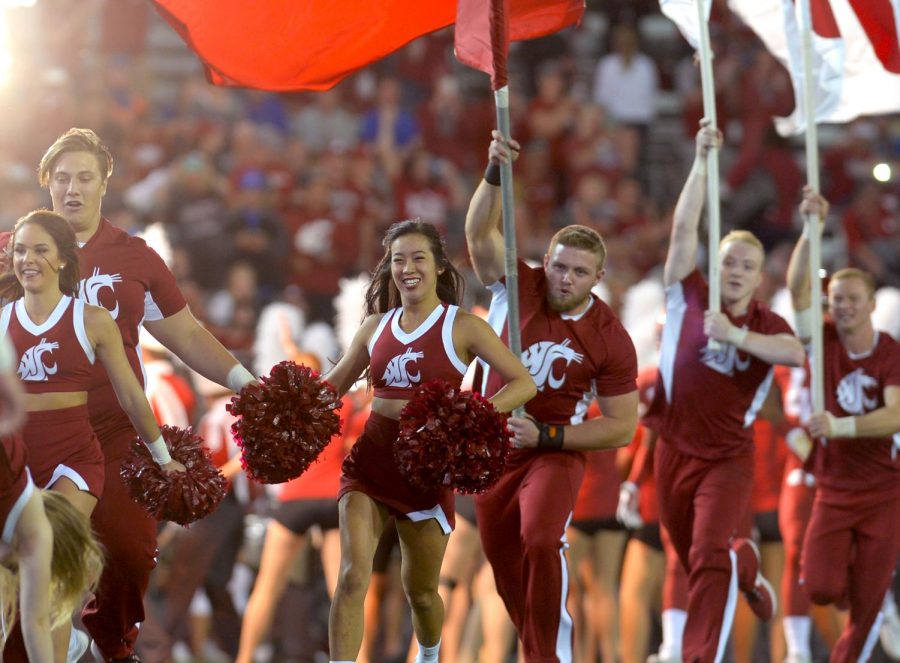 The WSU cheerleading team rush onto the field at the start of the game against Boise State University at Martin Stadium on Sept. 9. 