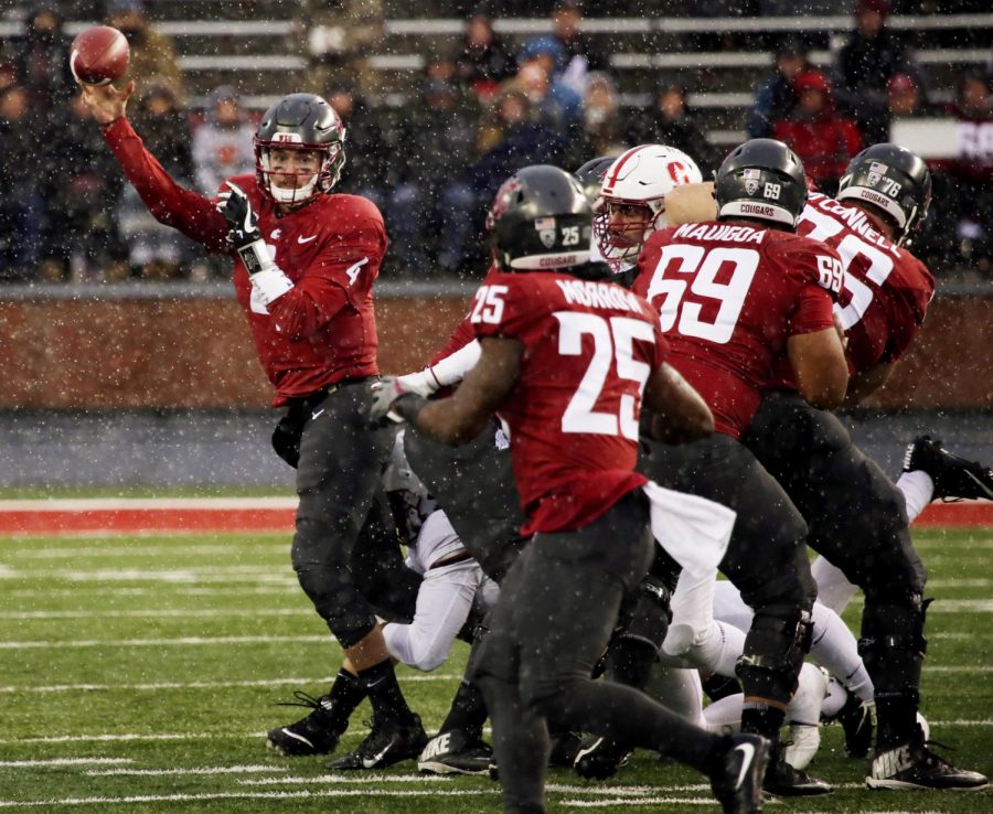 Redshirt senior quarterback Luke Falk tosses off the ball to Redshirt  Senior running back Jamal Morrow as he is being pulled to the ground by Stanford defensive players on Saturday at Martin Stadium.