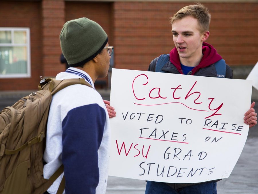 WSU Young Democrats member Jacob Woodbury protests and talks to passing students Monday morning on the Glenn Terrell Friendship Mall.