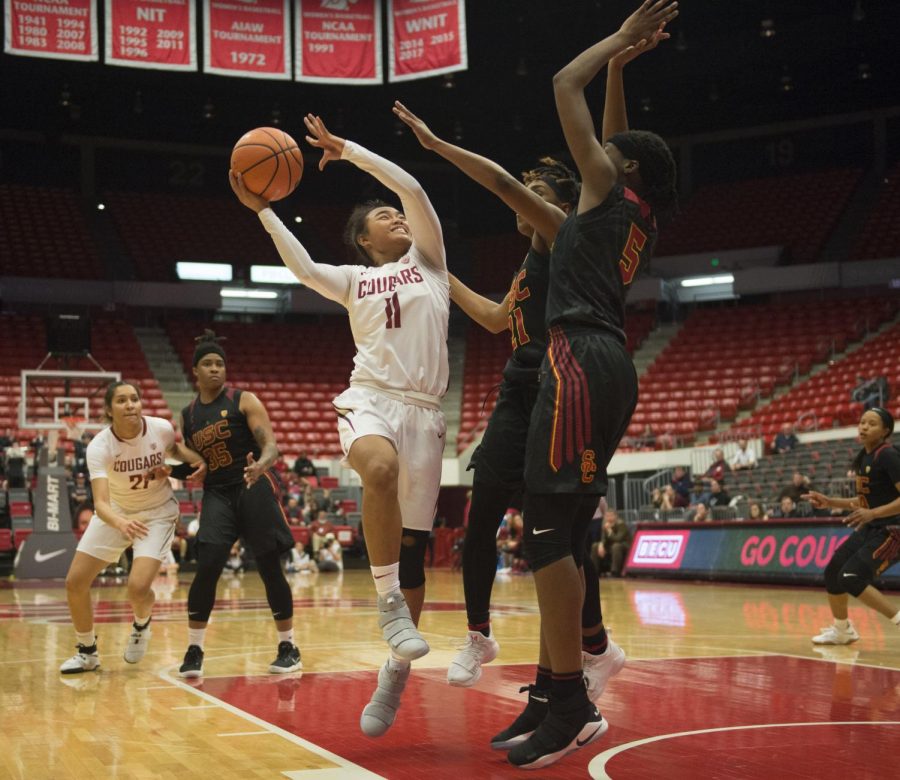 WSU sophomore guard Chanelle Molina goes for a layup over USC’s sophomore forward Ja’Tavia Tapley, right, and junior guard Aliyah Mazyck on Jan. 26 at Beasley Coliseum. WSU lost 73-72.
