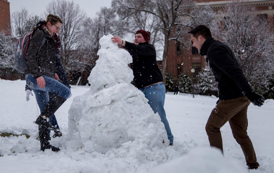 From left to right: Miranda Spence, Aaron Doull and Anguel Atanassov attempt to build a snowman between their classes Wednesday at Thompson Flats. 